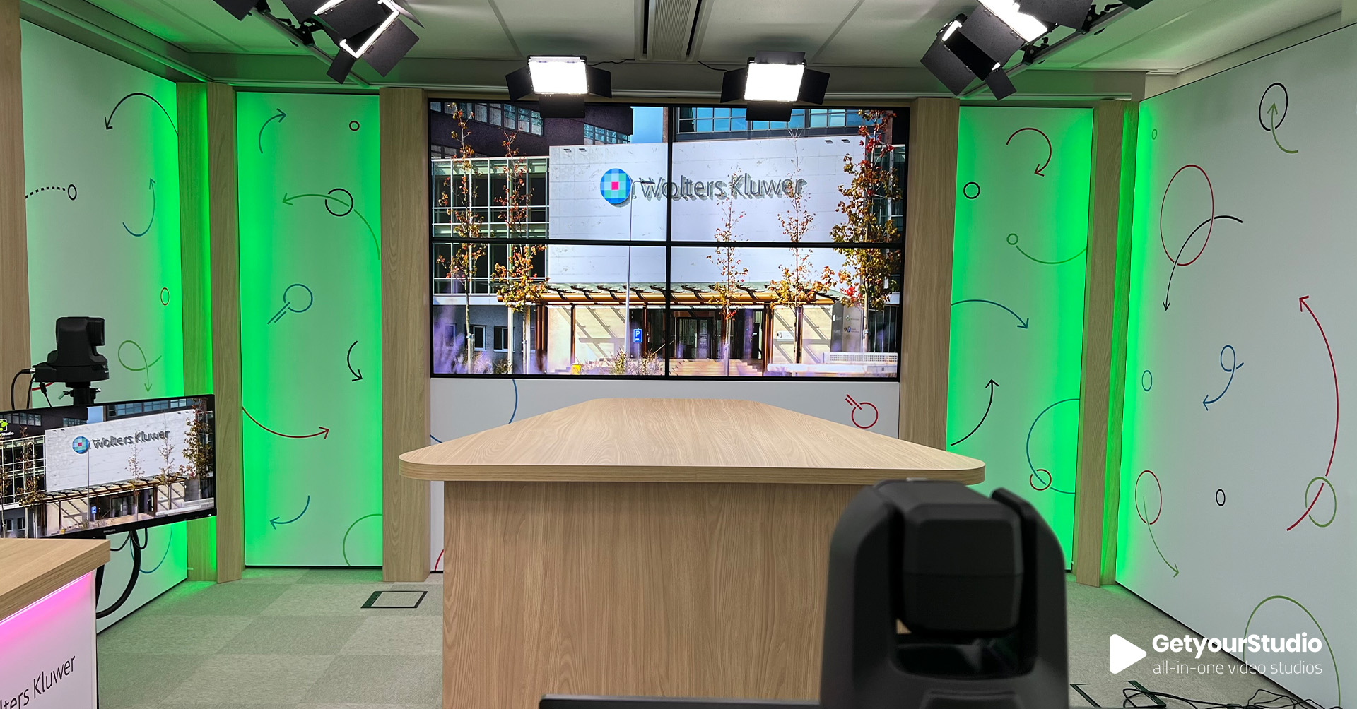 Corporate in-house studio van Wolters Kluwer, ontworpen door GetyourStudio met LED-verlichting, videowall en maatwerkdecor in huisstijl